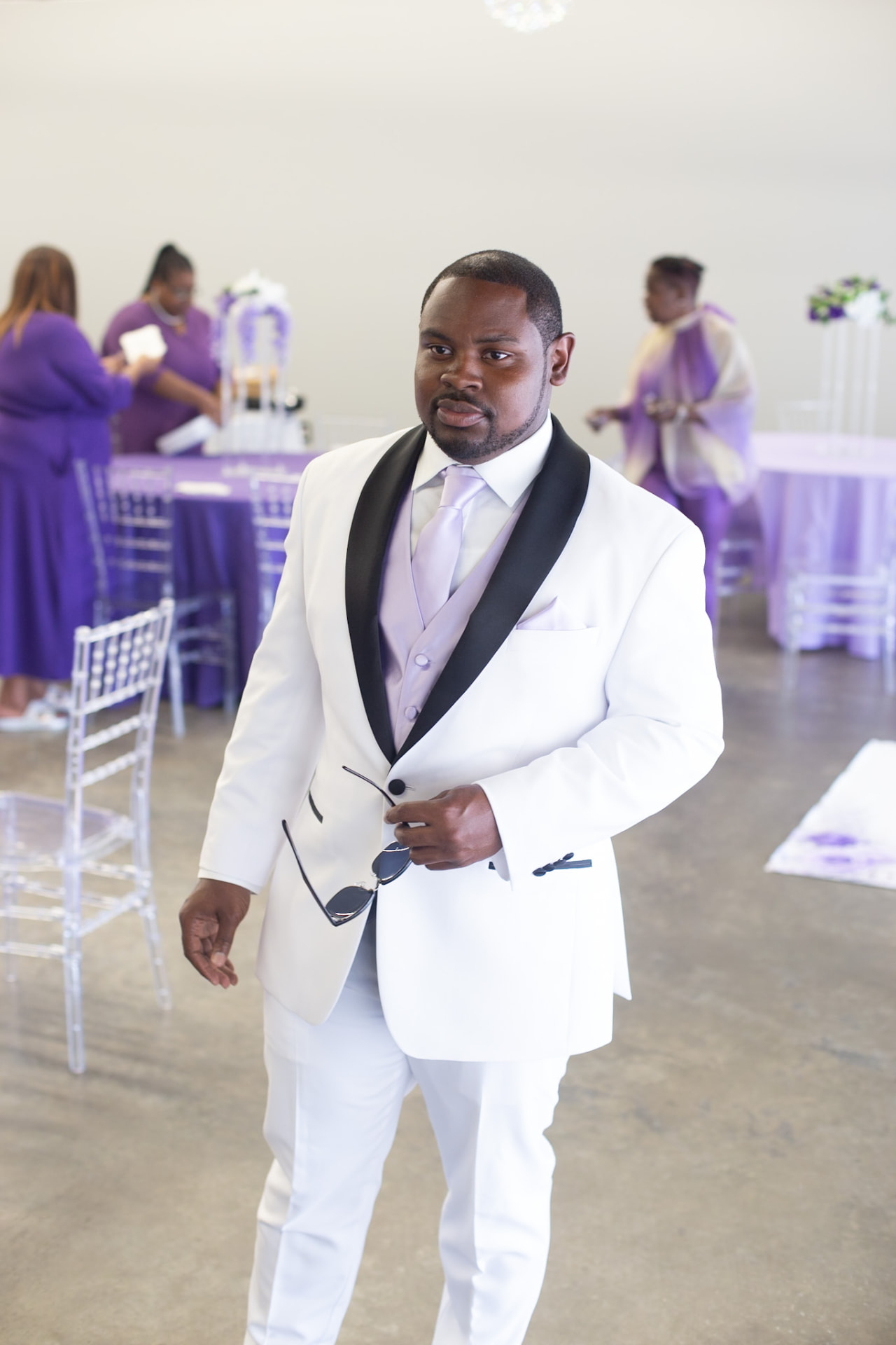 Wedding — groom in a white tuxedo with black shawl lapels and a lilac vest