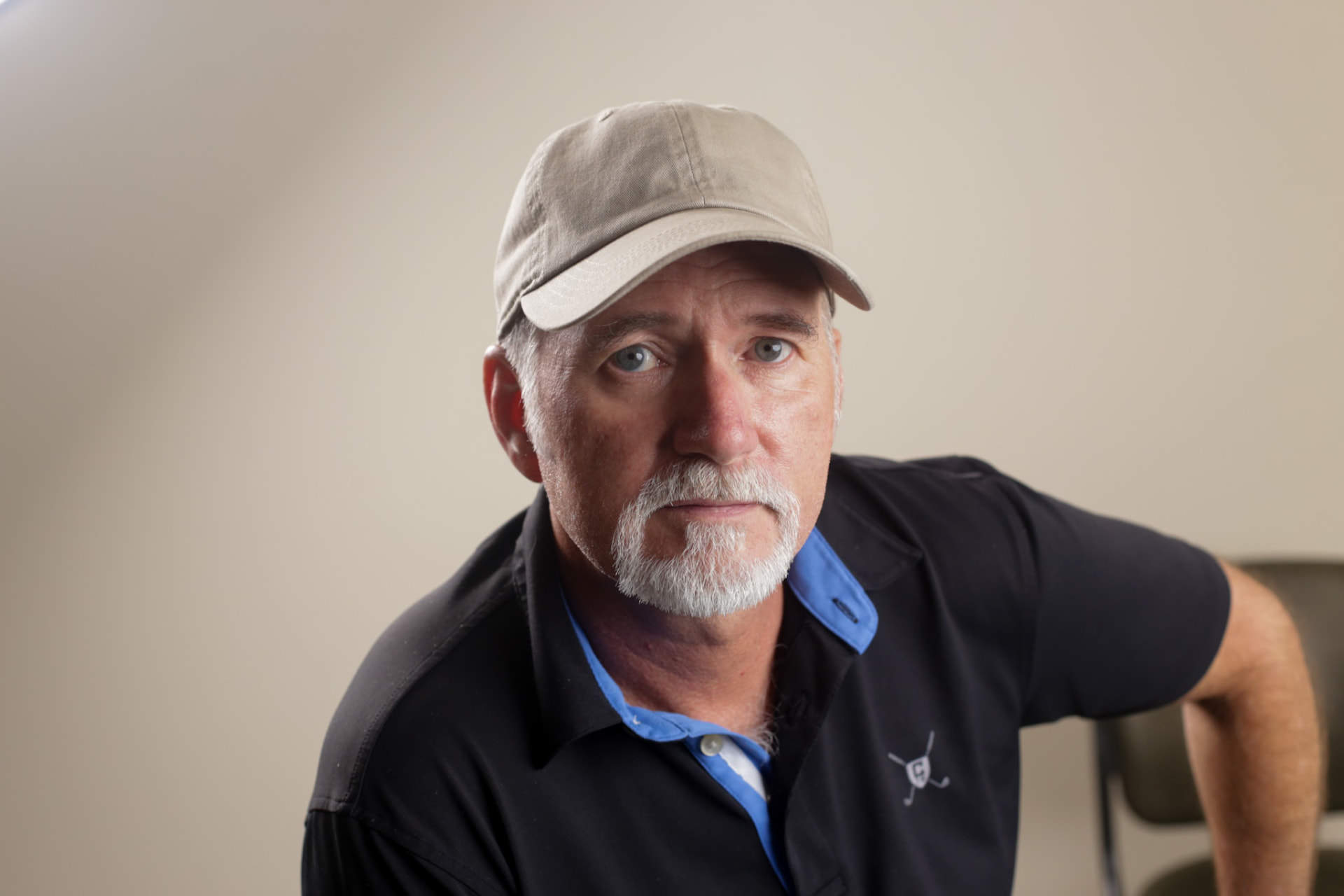 Portrait — golf pro in a cap, studio headshot