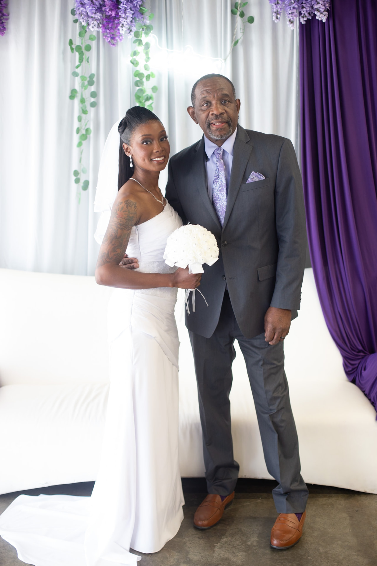 Wedding — bride and her father in the purple-draped reception hall