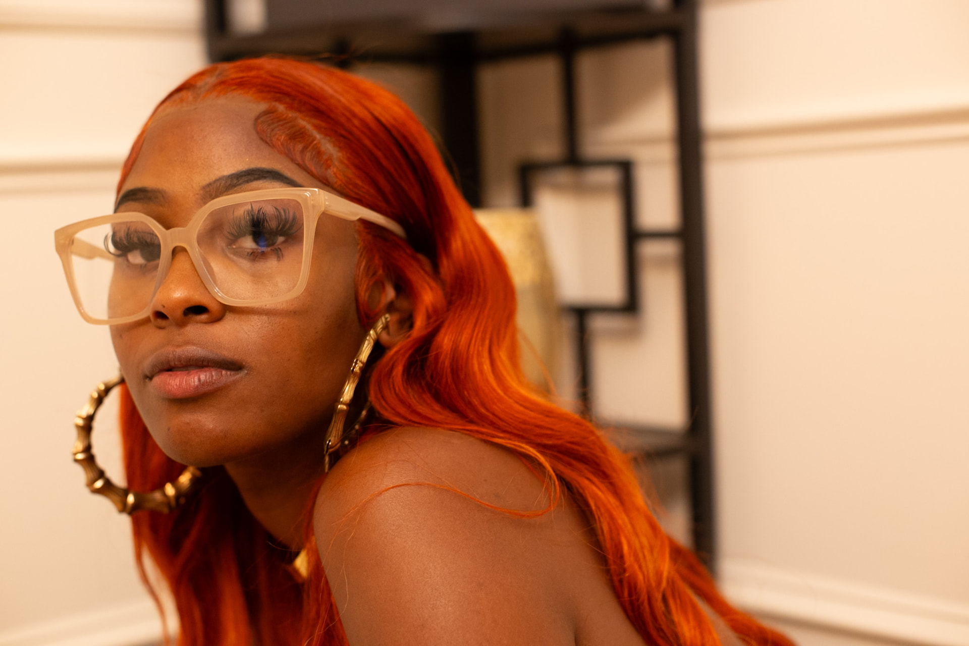Portrait — copper hair, bamboo hoops and clear frames in the studio