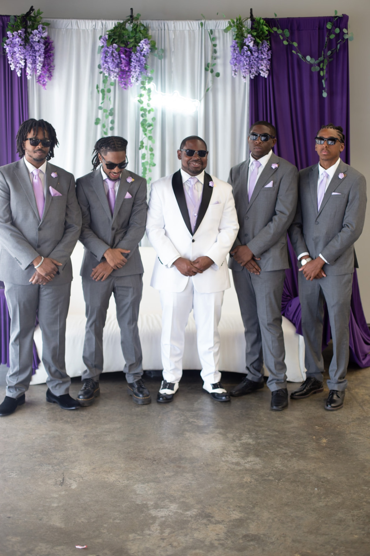 Wedding — the groom and his groomsmen in grey suits and lilac ties