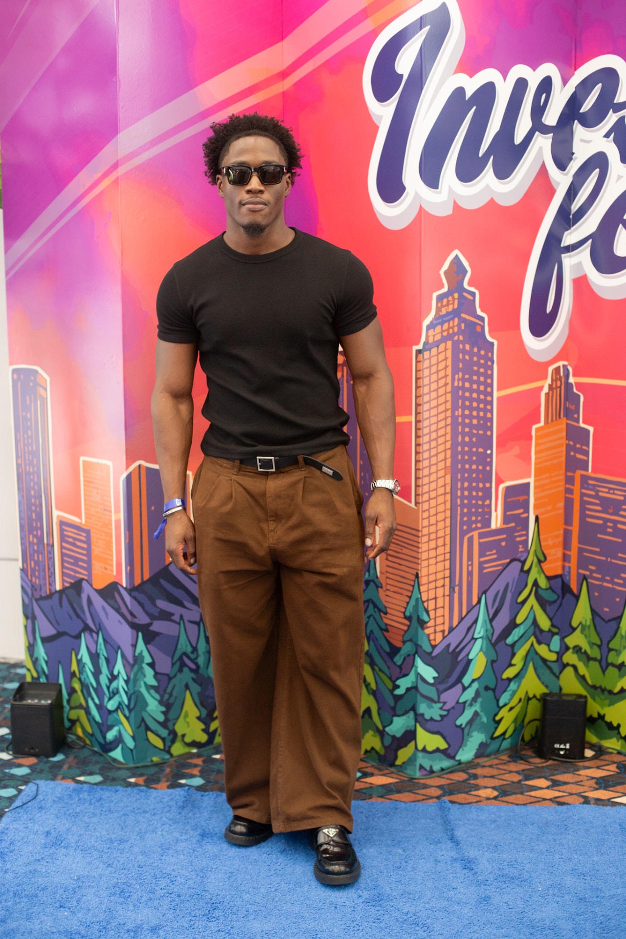 Invest Fest — guest in shades on the Invest Fest blue carpet